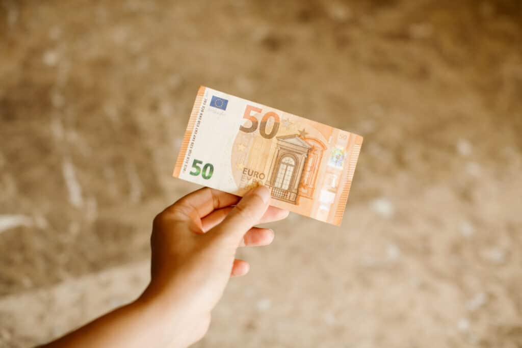 Hand holding a 50 euros banknote as background. Euro cash background. Close up view of euro banknote in hand.